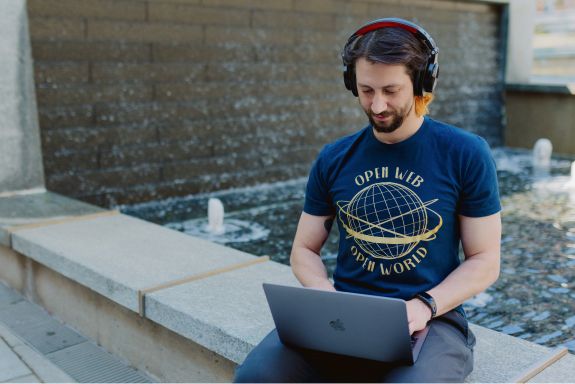 Man with headphones looking at laptop screen